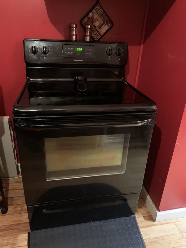 Upright Frigidaire refrigerator in black and a Frigidaire ceramic top