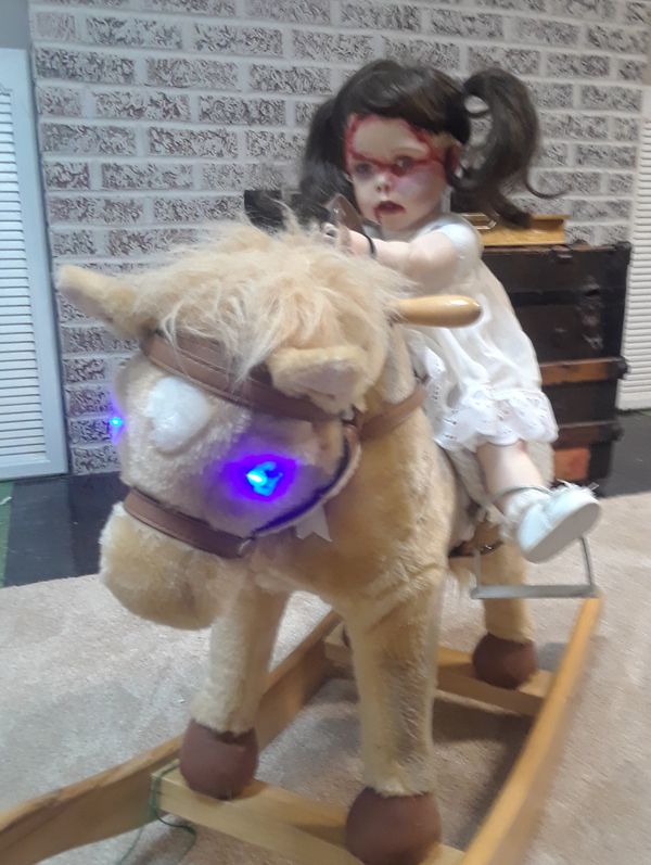 animated demon doll on rocking horse