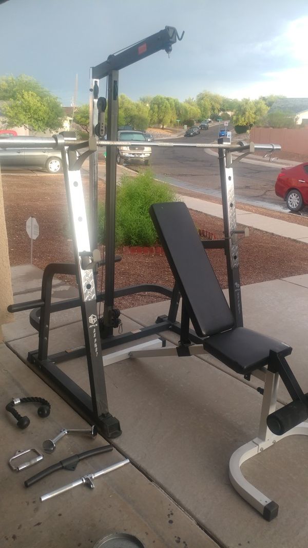 Weight bench with squat rack, pulley system, Olympic barbell and attachments for Sale in Tucson
