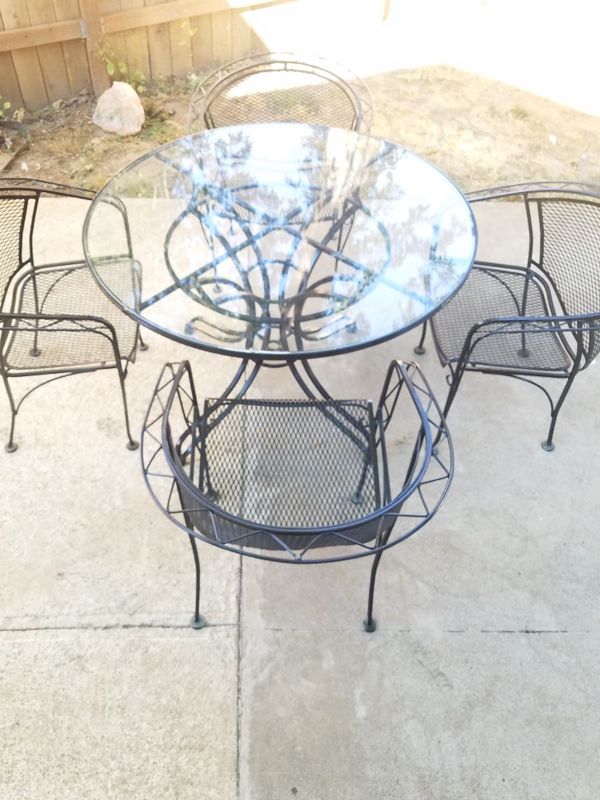 Wrought iron patio set glass top table with four chairs for Sale in